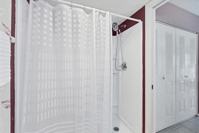 bathroom featuring tile patterned flooring, a textured ceiling, and walk in shower