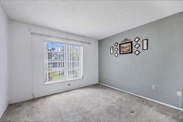 empty room featuring a textured ceiling and carpet