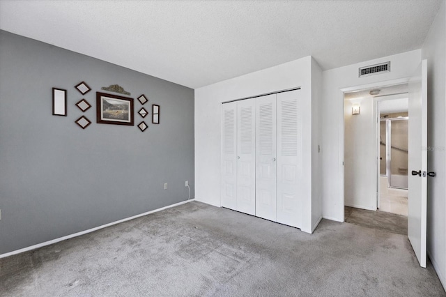 unfurnished bedroom with a closet, carpet floors, and a textured ceiling