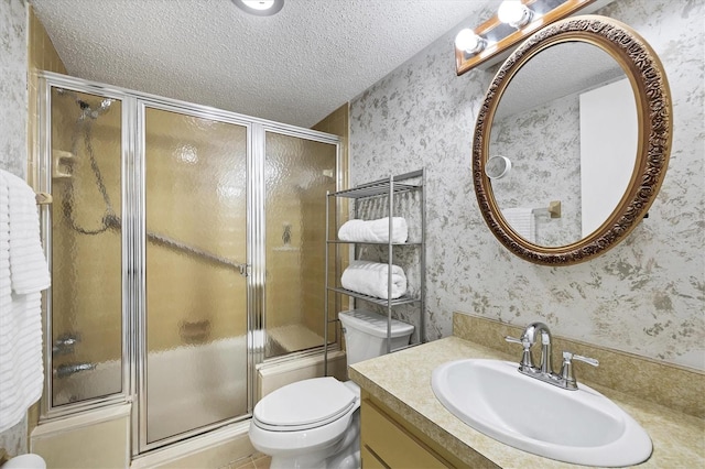 bathroom featuring walk in shower, a textured ceiling, vanity, and toilet