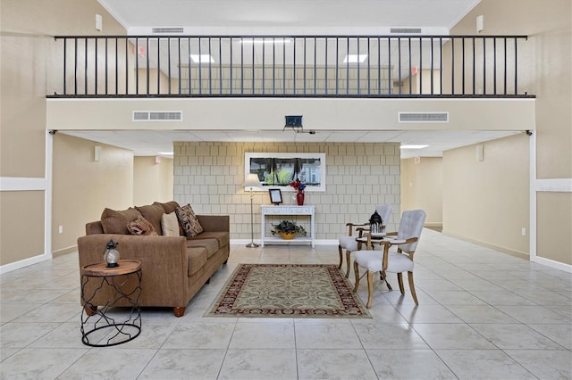 living room featuring tile walls, crown molding, and light tile patterned floors