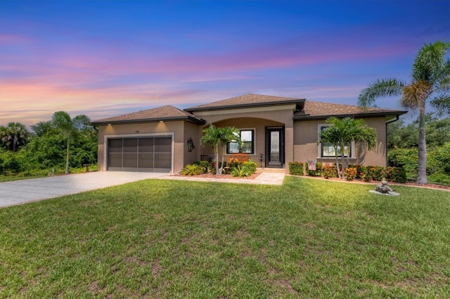 view of front of property with a garage and a yard