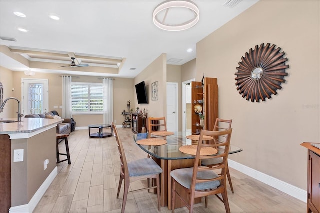 dining space with ceiling fan, sink, and light hardwood / wood-style floors