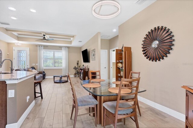 191 Brig Cir W, Placida, FL 33946 - dining room featuring baseboards, a tray ceiling, light wood-style flooring, and ceiling fan
