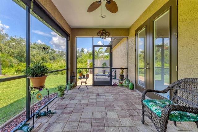 unfurnished sunroom featuring ceiling fan