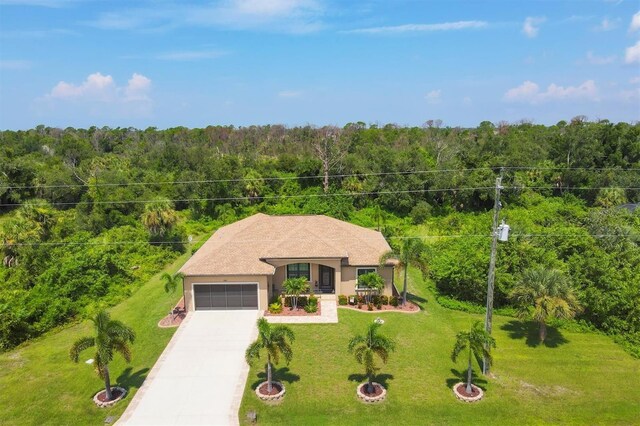 191 Brig Cir W, Placida, FL 33946 - view of front of home featuring driveway, a garage, a front lawn, and a forest view