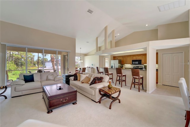 carpeted living room with high vaulted ceiling