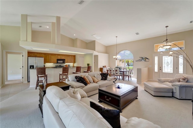 carpeted living room with high vaulted ceiling and a chandelier