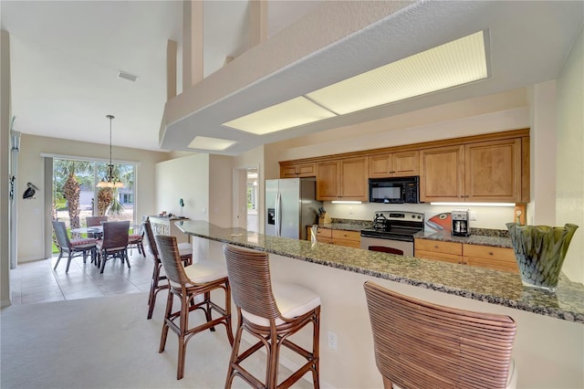 kitchen featuring light colored carpet, stone counters, pendant lighting, and stainless steel appliances