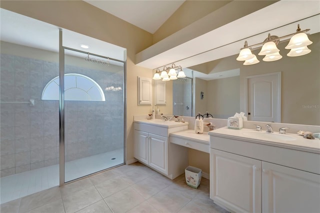 bathroom featuring tile patterned flooring, double vanity, lofted ceiling, and tiled shower