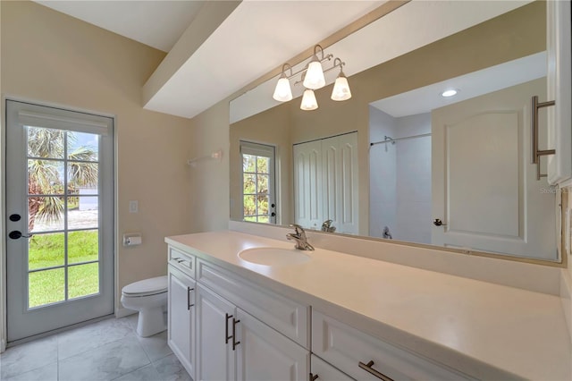 bathroom featuring tile patterned flooring, toilet, vanity, and a wealth of natural light