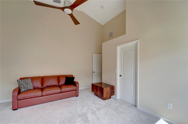 carpeted living room with ceiling fan and high vaulted ceiling