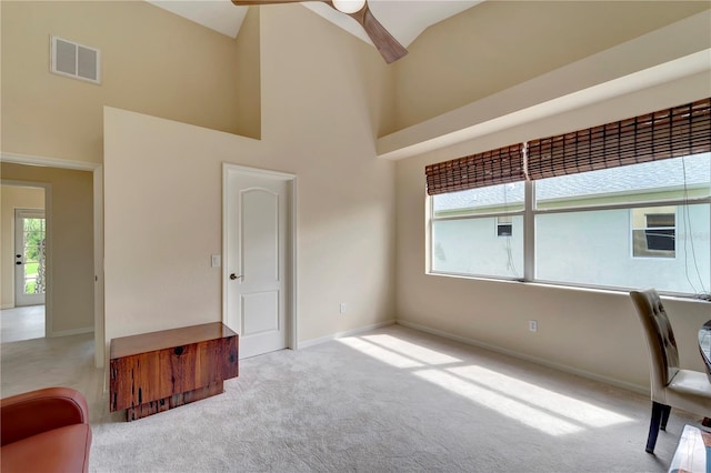 interior space with high vaulted ceiling, ceiling fan, and light colored carpet