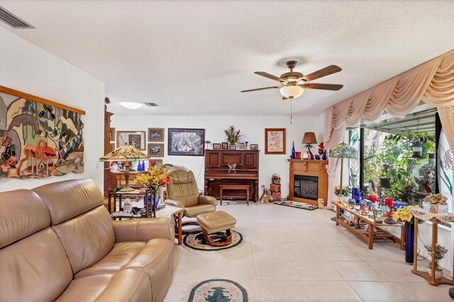 tiled living room featuring ceiling fan and a textured ceiling