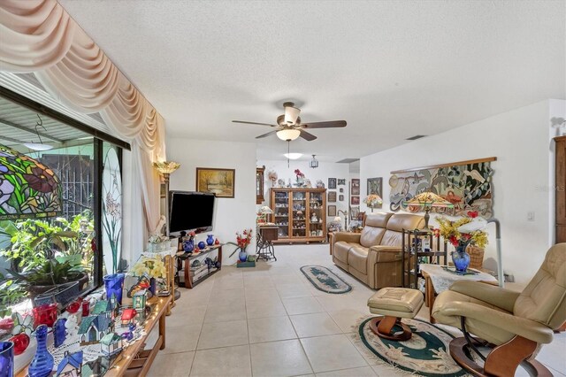 tiled living room with a textured ceiling and ceiling fan