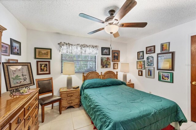 tiled bedroom featuring ceiling fan and a textured ceiling