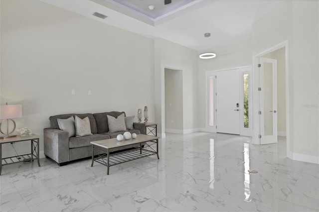 living area featuring marble finish floor, visible vents, and baseboards