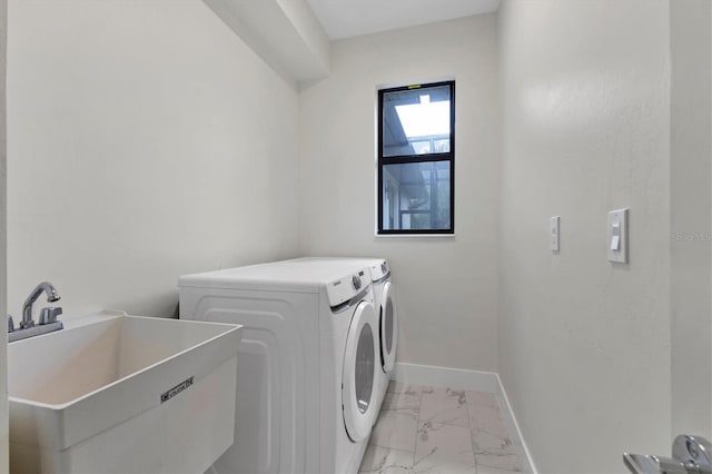 laundry area with marble finish floor, washing machine and clothes dryer, a sink, laundry area, and baseboards