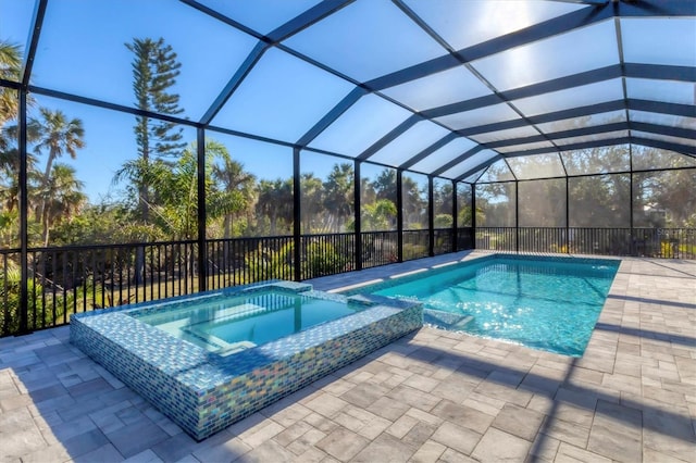 view of pool featuring a pool with connected hot tub, a patio, and a lanai