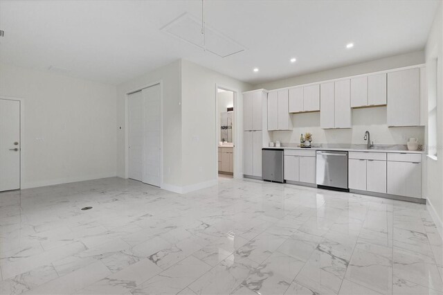 kitchen featuring light countertops, baseboards, white cabinetry, and stainless steel dishwasher