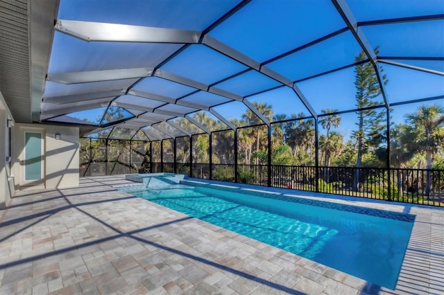 view of swimming pool featuring glass enclosure, a patio area, and a fenced in pool