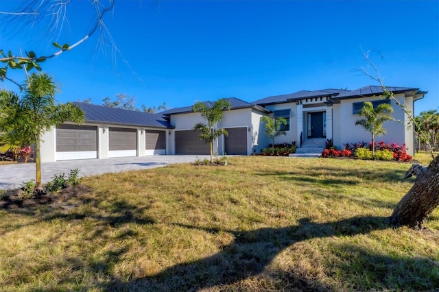 prairie-style home with a front yard, driveway, an attached garage, and stucco siding