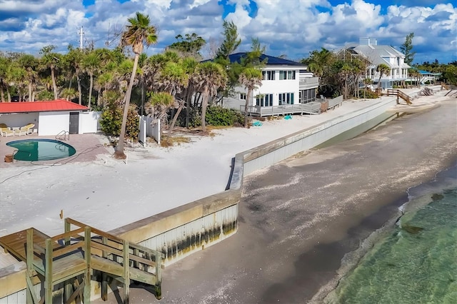 exterior space with a water view and a beach view