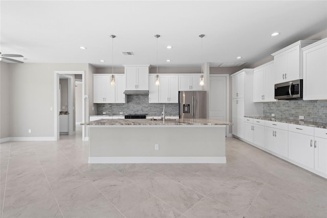 kitchen with appliances with stainless steel finishes, white cabinetry, pendant lighting, ceiling fan, and an island with sink