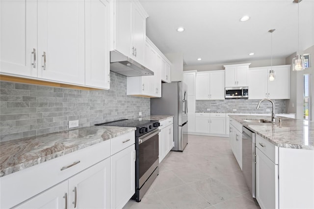 kitchen with stainless steel appliances, decorative light fixtures, decorative backsplash, sink, and light stone counters