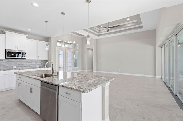 kitchen featuring sink, white cabinetry, stainless steel appliances, and a kitchen island with sink