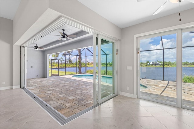 doorway to outside featuring ceiling fan, a water view, and light tile patterned floors