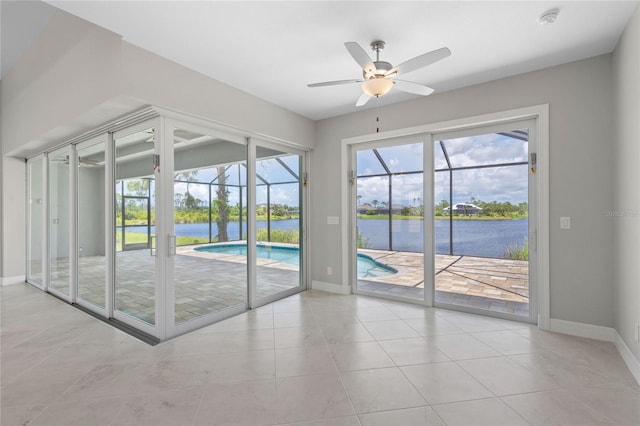 entryway with a water view, light tile patterned flooring, and ceiling fan