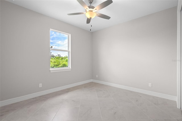 tiled spare room with ceiling fan