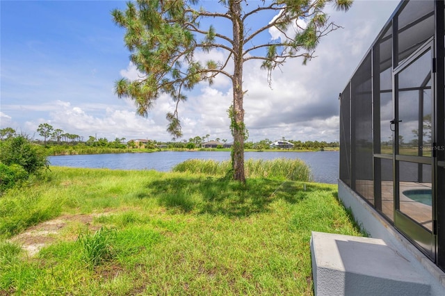 view of yard featuring glass enclosure and a water view