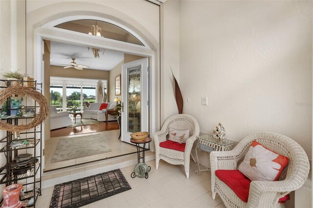 living area featuring ceiling fan and light tile patterned floors