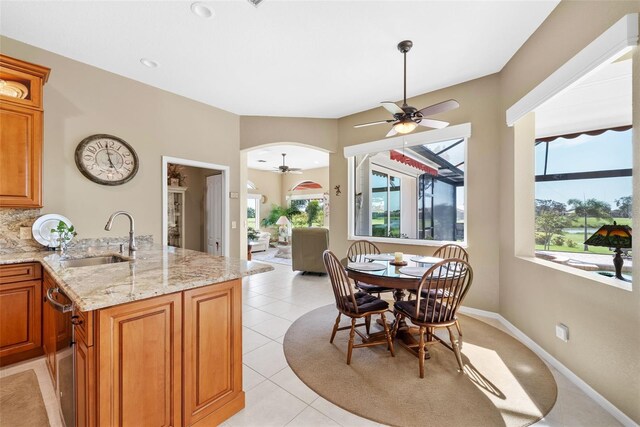 dining room featuring ceiling fan, sink, and light tile patterned flooring