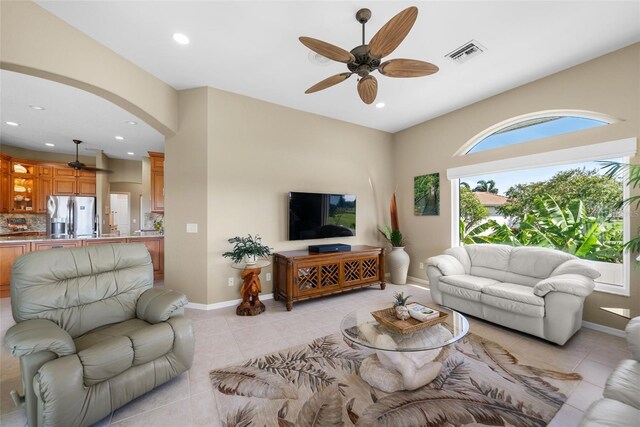 tiled living room featuring ceiling fan and a healthy amount of sunlight