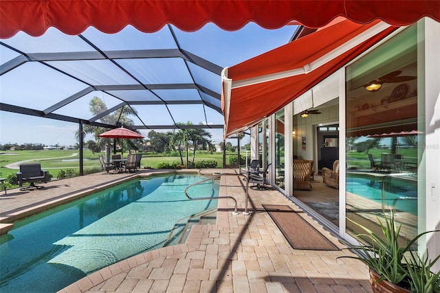 view of swimming pool featuring ceiling fan, a patio area, and a lanai