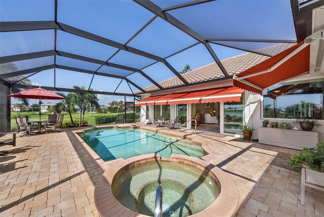 view of pool featuring glass enclosure, a patio area, and an in ground hot tub