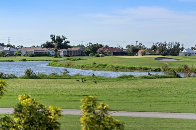 view of home's community with a lawn and a water view