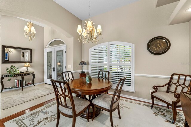 dining area featuring vaulted ceiling, french doors, and a chandelier