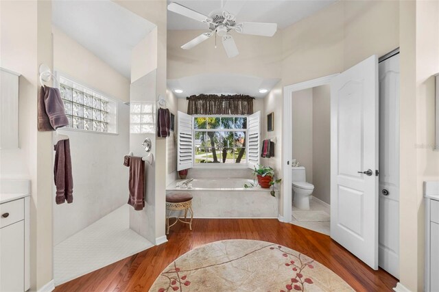 bathroom featuring a tub, vanity, hardwood / wood-style floors, and toilet