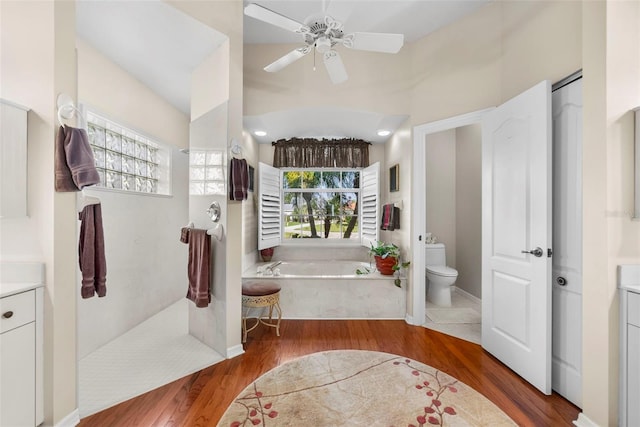 full bathroom with a garden tub, vanity, toilet, and wood finished floors