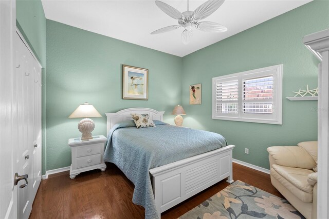 bedroom with ceiling fan, a closet, and dark wood-type flooring