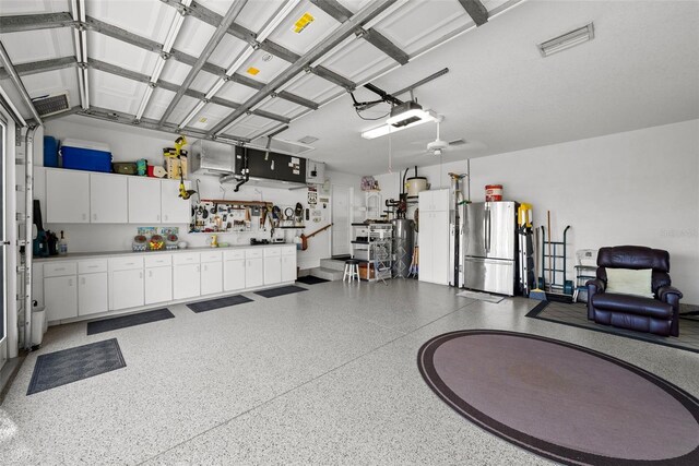 garage featuring stainless steel refrigerator and a workshop area