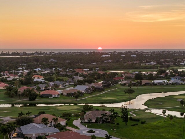 aerial view at dusk featuring a water view