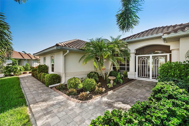 view of side of property featuring a tile roof and stucco siding