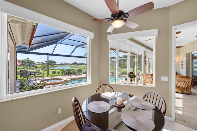 dining area featuring a sunroom, ceiling fan, and baseboards