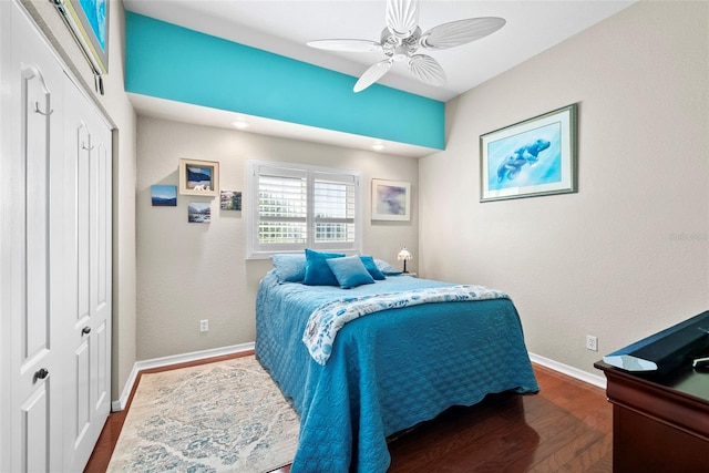 bedroom with a ceiling fan, a closet, baseboards, and wood finished floors