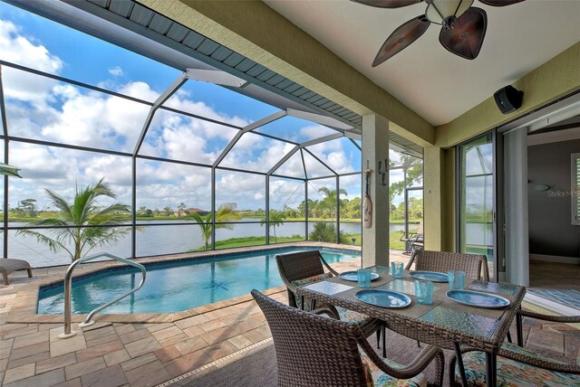 view of pool featuring a water view, ceiling fan, a patio, and glass enclosure